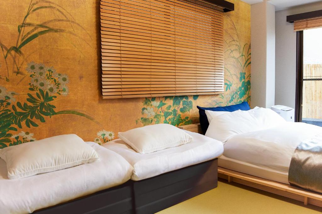 Dos camas una al lado de la otra en un dormitorio. en Asakusa Premium Stay 彩-Irodori-, en Tokio
