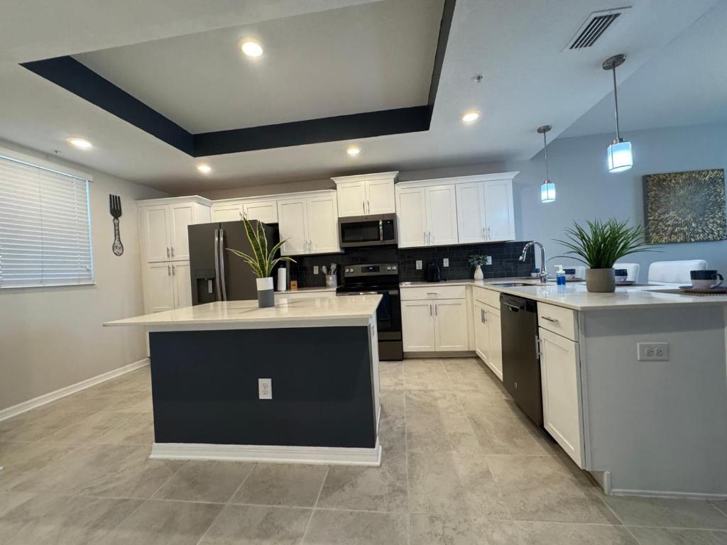 a large kitchen with white cabinets and white counter tops at 2 Bedrooms Apartment in Storey Lake in Kissimmee
