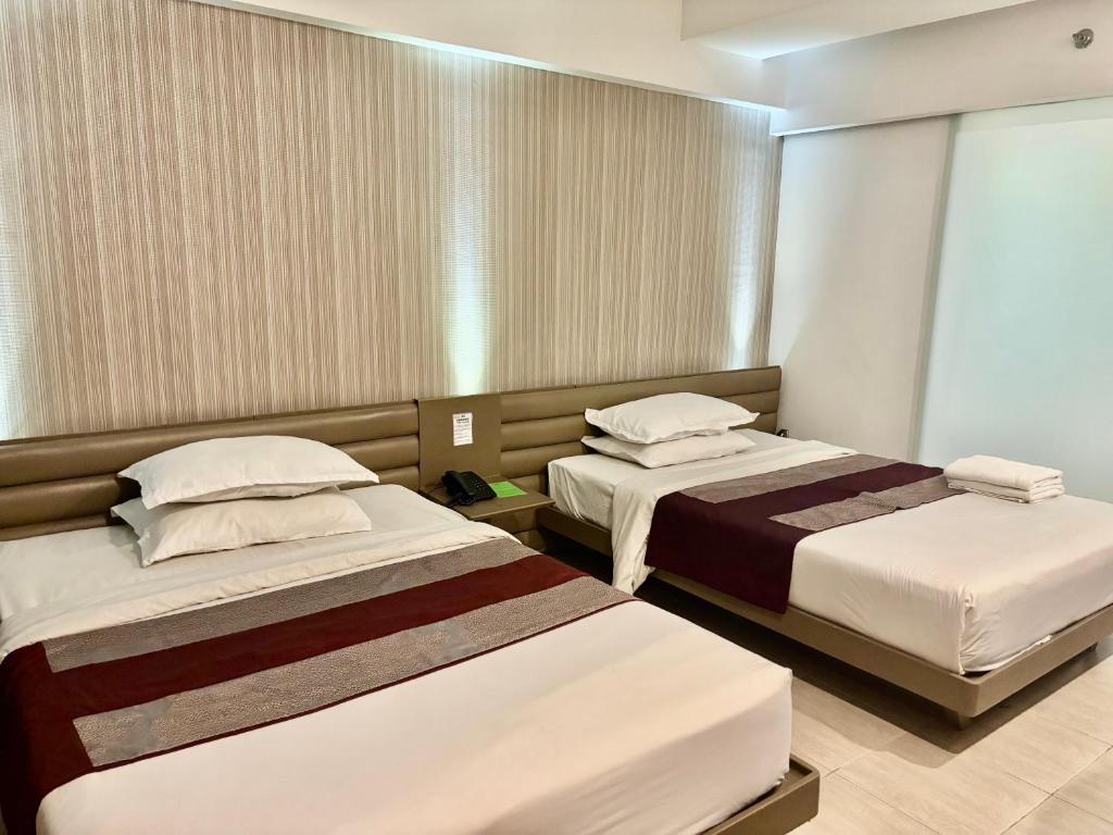 Postel nebo postele na pokoji v ubytování The E-Hotel Makati