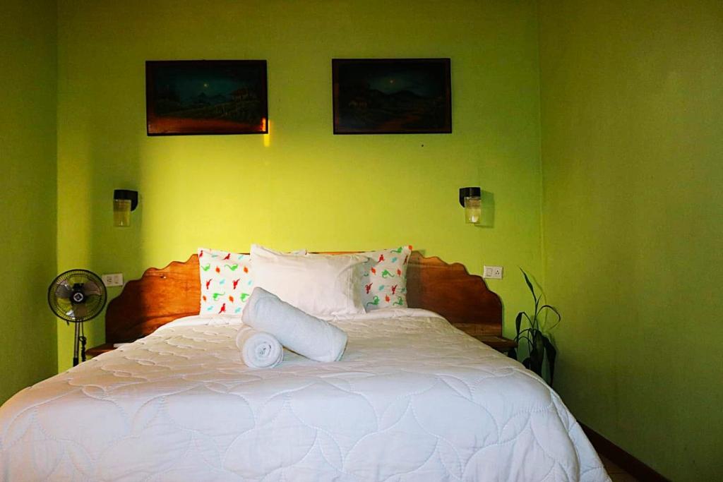 a bedroom with a white bed with three pictures on the wall at Siary Aparment con vista 3 in Monteverde Costa Rica