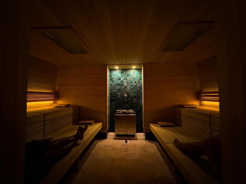 a dark room with benches and a fireplace at Rascals Hotel - Adults Only in Kuta Lombok