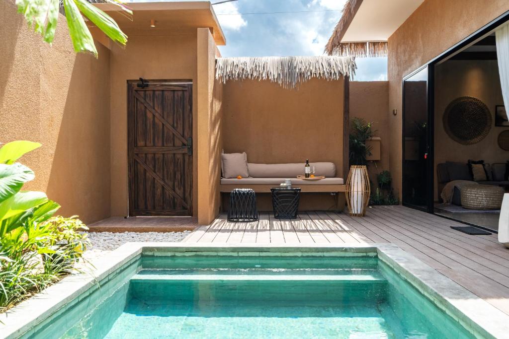 une piscine dans l'arrière-cour d'une villa avec un canapé dans l'établissement Nawasena Villa B - Earthy Luxury Villa, Walk to Beach in Pererenan, à Cemagi