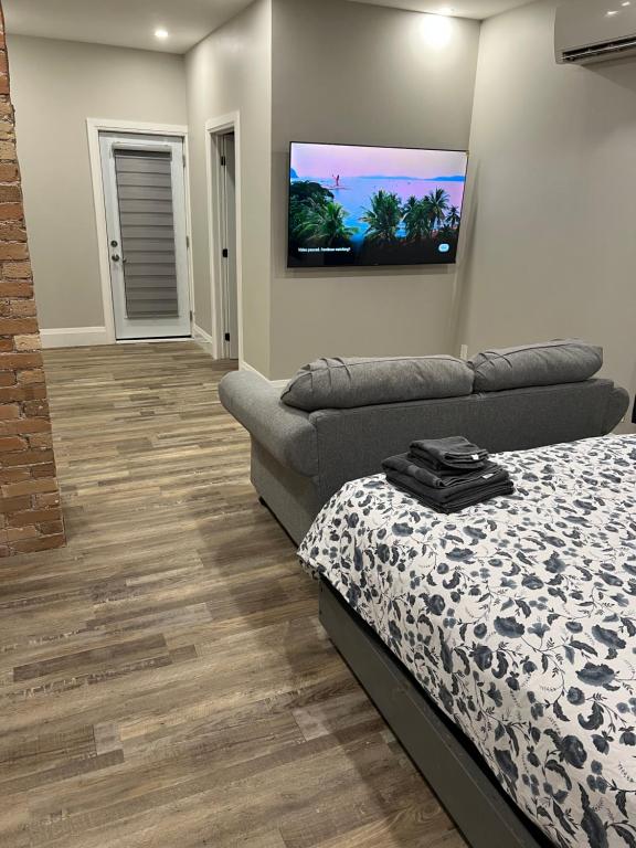 a living room with a bed and a couch at ENTIRE BACHELOR UNIT EN-SUITE ACROSS FROM GOOGLE - br2 in Kitchener