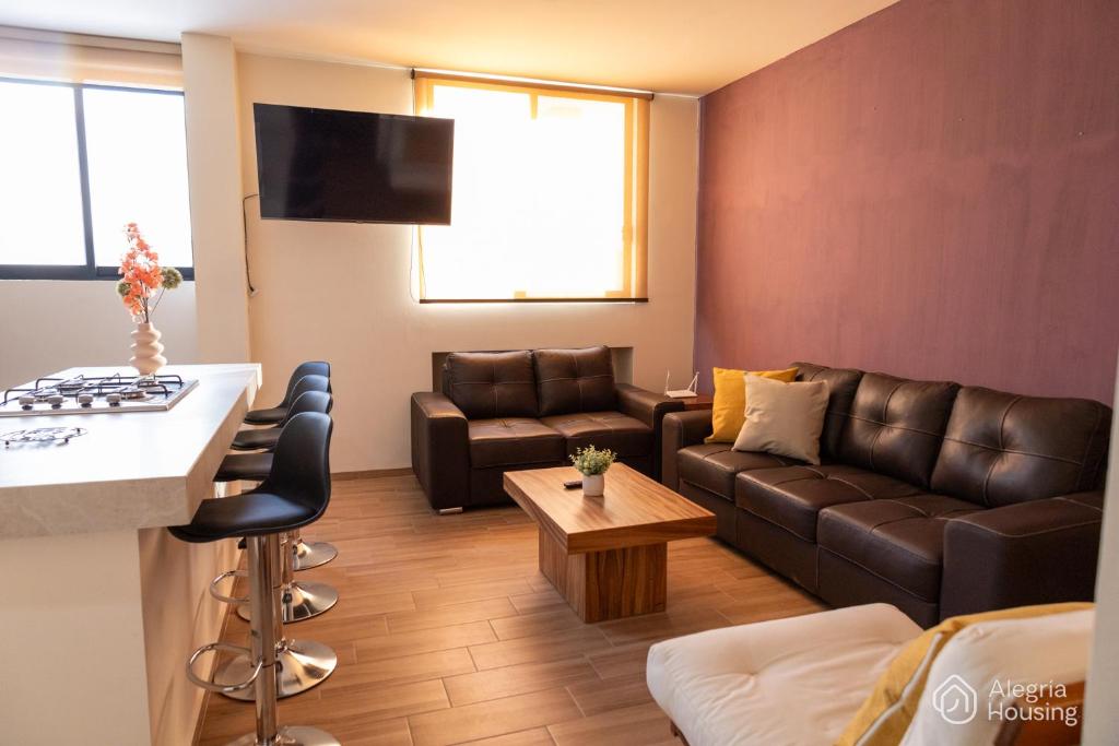 ein Wohnzimmer mit Sofa und Tisch in der Unterkunft T - Apartamento Privado - Alegría Housing in Aguascalientes