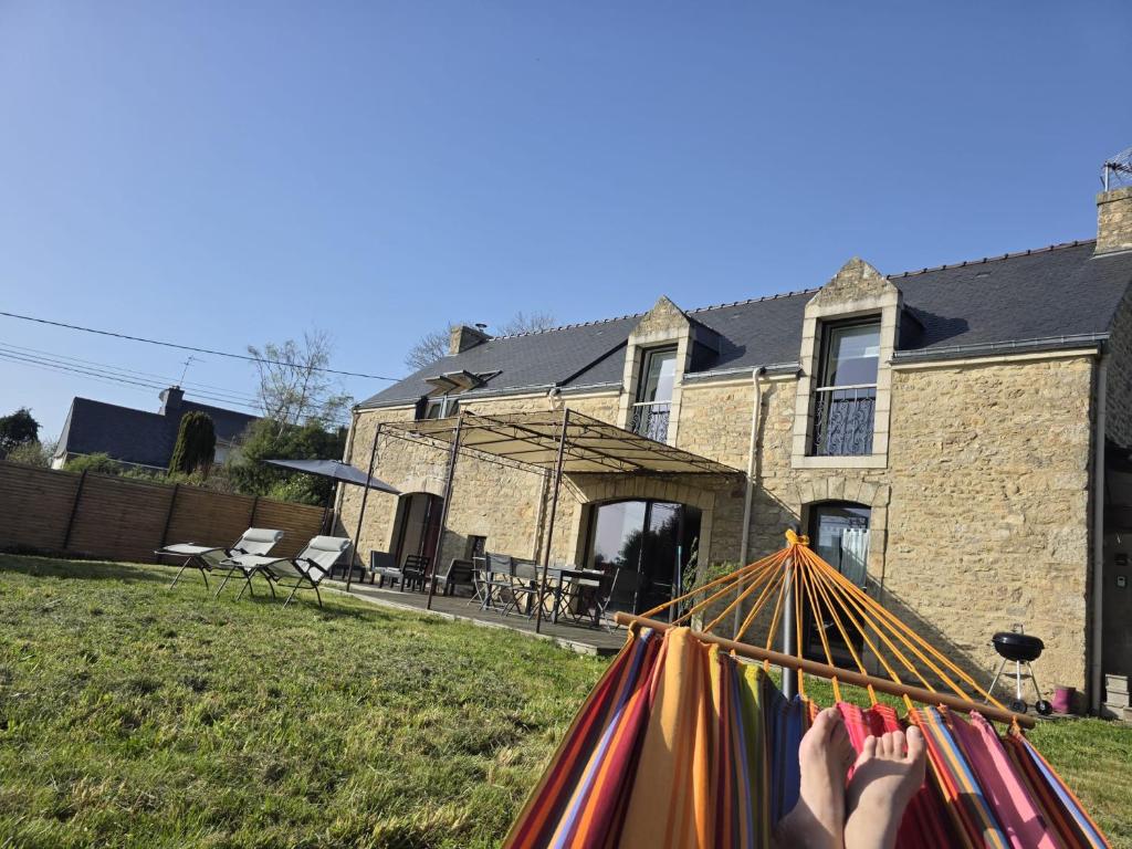 une personne assise dans un hamac devant une maison dans l'établissement TY MIALY, à Erdeven