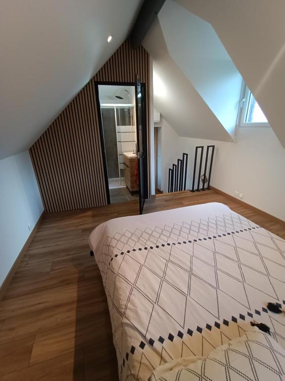 une chambre avec un grand lit dans un grenier dans l'établissement Studio en duplex 24H du Mans, à Étival-lès-Le Mans