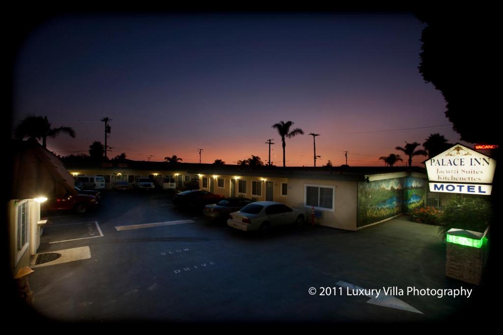 a motel with cars parked in a parking lot at night at The Palace Inn in Oxnard