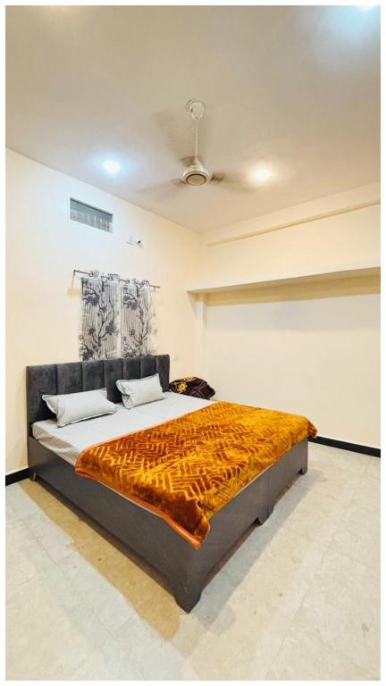 a bedroom with a bed with a blanket on it at JOSHI JII Ujjain in Ujjain