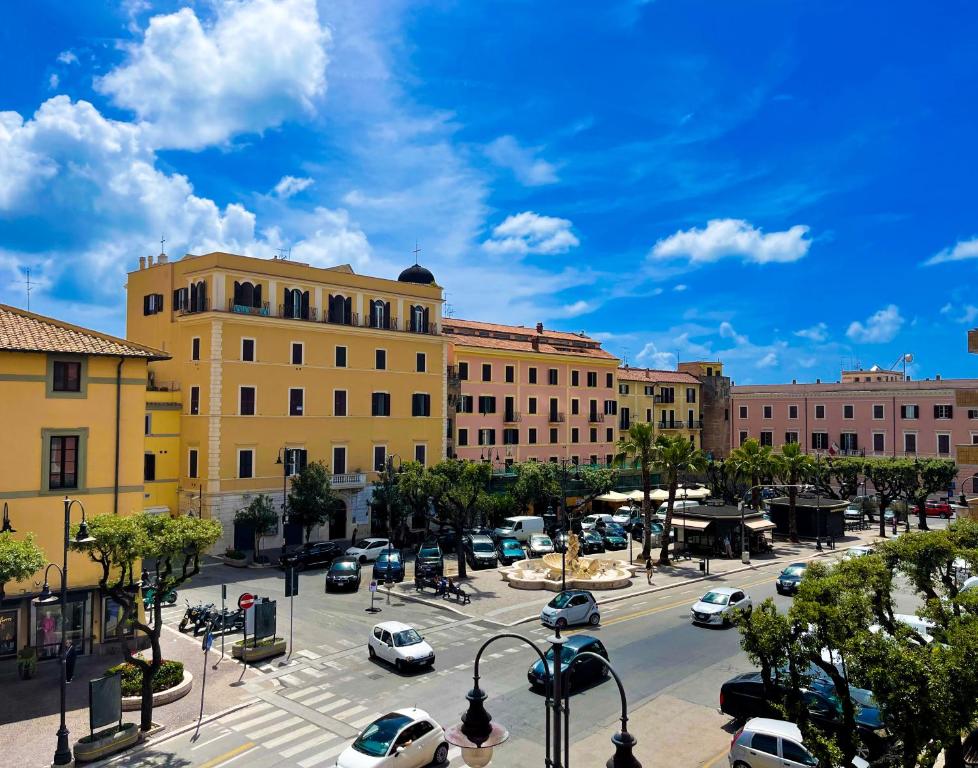 a city street with cars parked in front of buildings at NIMPHAEA BLUE APARTMENT - Elegant Central Flat, Walk to Beach & Train Station in Nettuno