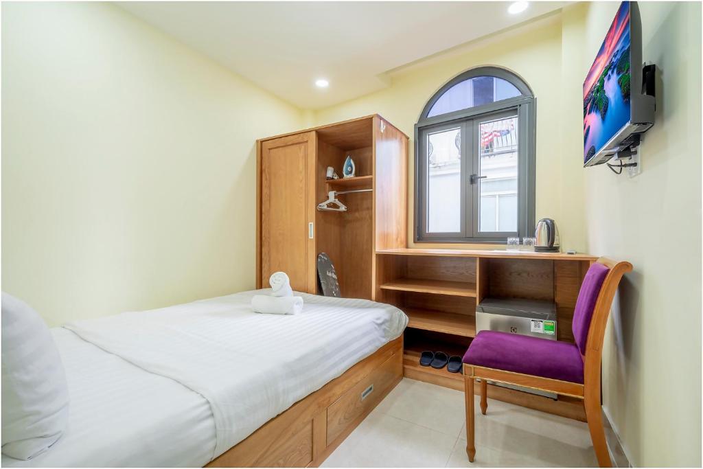 a bedroom with a bed and a desk and a window at NU House - Private Room in Heart of District 1 - Walk to Everything in Ho Chi Minh City
