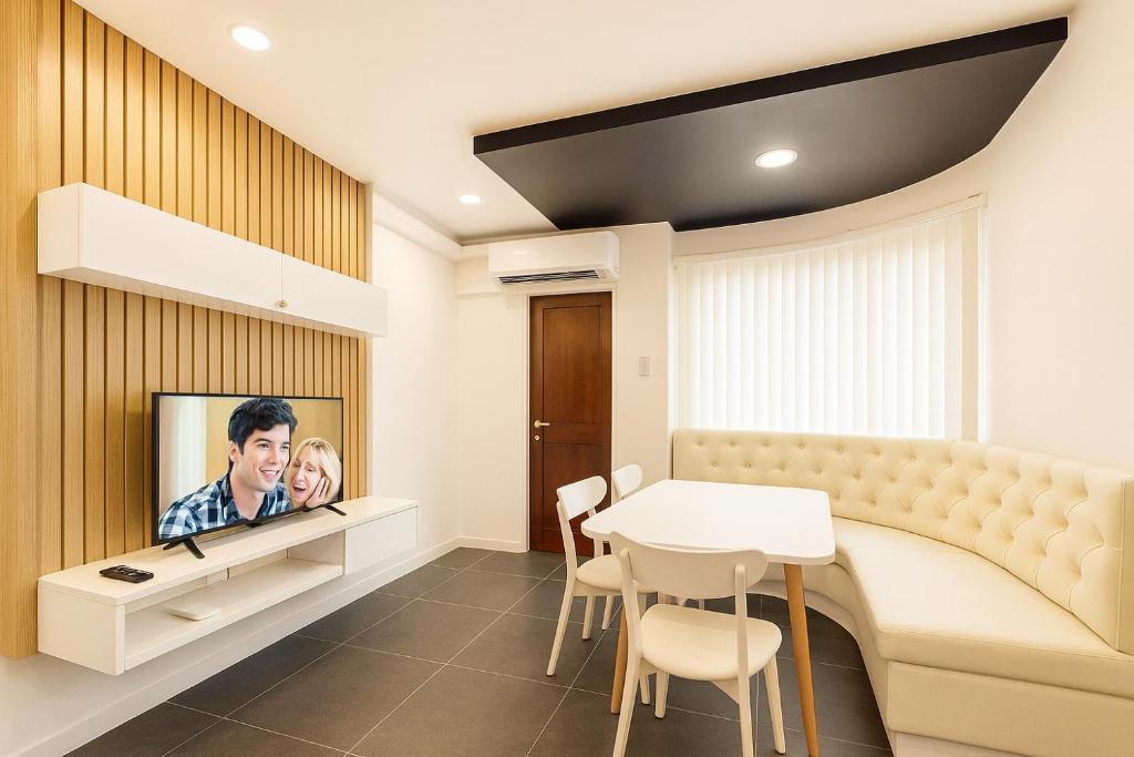 a living room with a tv and a table at Modern and Stylish Bachelors Pad in San Josef