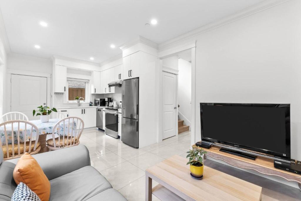 un soggiorno con un divano e una grande TV di Modern Private 3BR House a Vancouver