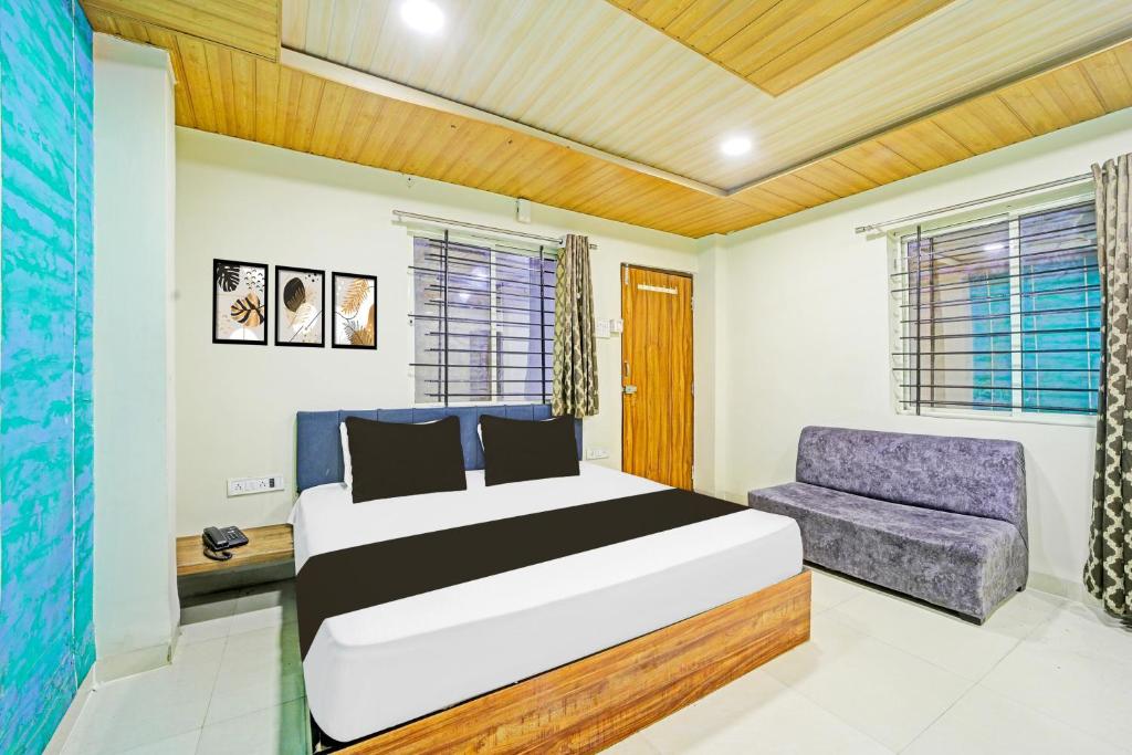 a bedroom with a bed and a couch at Collection O Ring Road Bhawarkua Indore in Indore