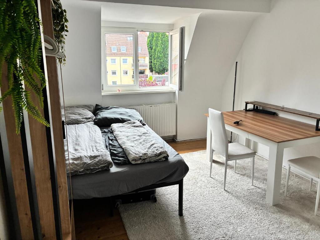 a bedroom with a bed and a desk and a table at Holidays loft, Private Rooms in a Friendly shared apartment in Nürnberg