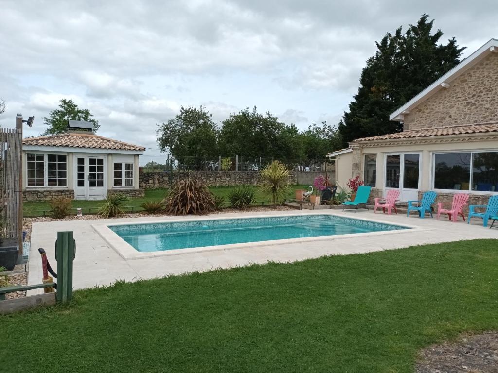 une piscine dans une cour à côté d'une maison dans l'établissement gite des 4 saisons, à Blasimon