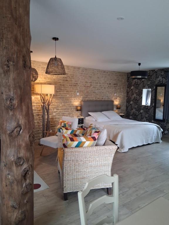 a bedroom with a bed and a chair in it at Bergerie de l'Iris in Sainte-Croix-sur-Mer