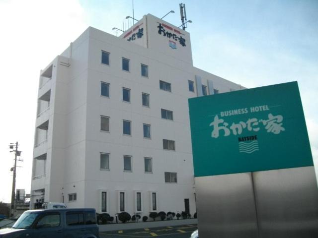 ein weißes Gebäude mit einem Schild davor in der Unterkunft Okadaya Bayside in Toyohashi