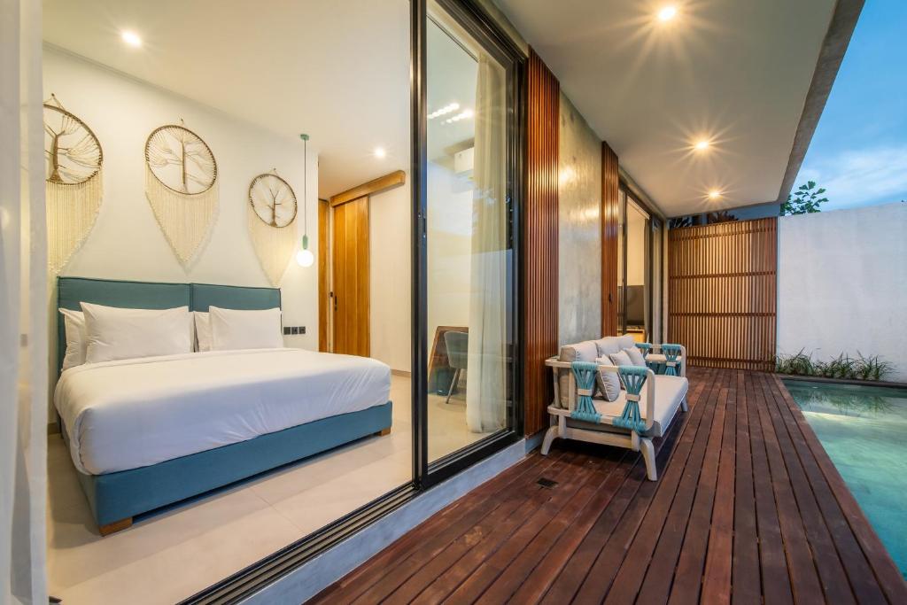 a bedroom with a bed and a swimming pool at Sunny Village Berawa in Canggu