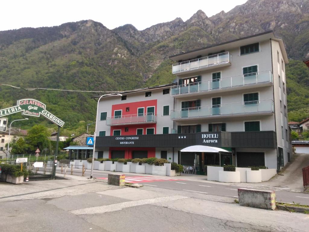 un edificio en una calle frente a una montaña en Hotel Aurora, en Chiavenna