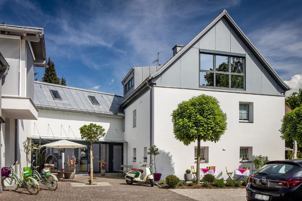una casa blanca con una moto aparcada en un aparcamiento en B&B Villa Verde, en Salzburgo