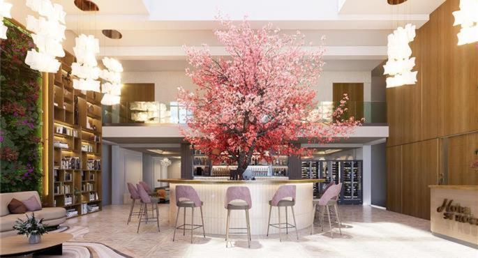 a room with a table and chairs and a tree at Best Western Plus Hotel Saint-Roch Orleans in Orléans