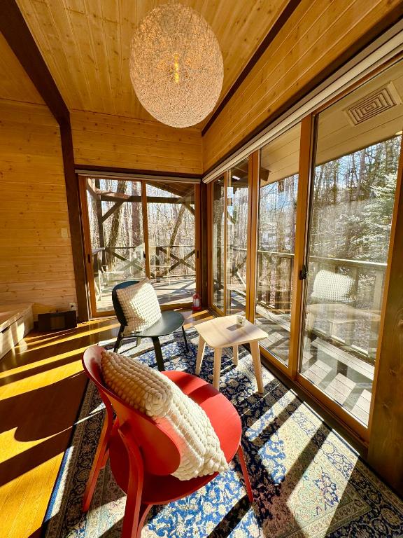 a living room with a chandelier and chairs in a house at Second House ホッポッタ in Kita-karuizawa