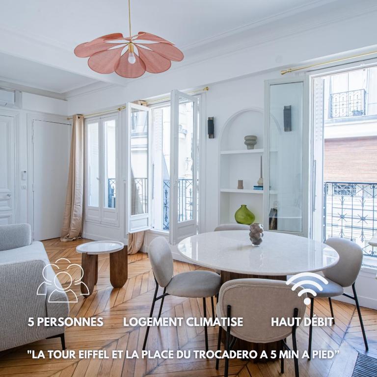 un salon blanc avec une table et des chaises dans l'établissement Le Trocadero - 5 minutes à pied de la Tour Eiffel - Place Trocadero - 5 personnes - Cadre Exceptionnel - Entièrement Climatisé, à Paris