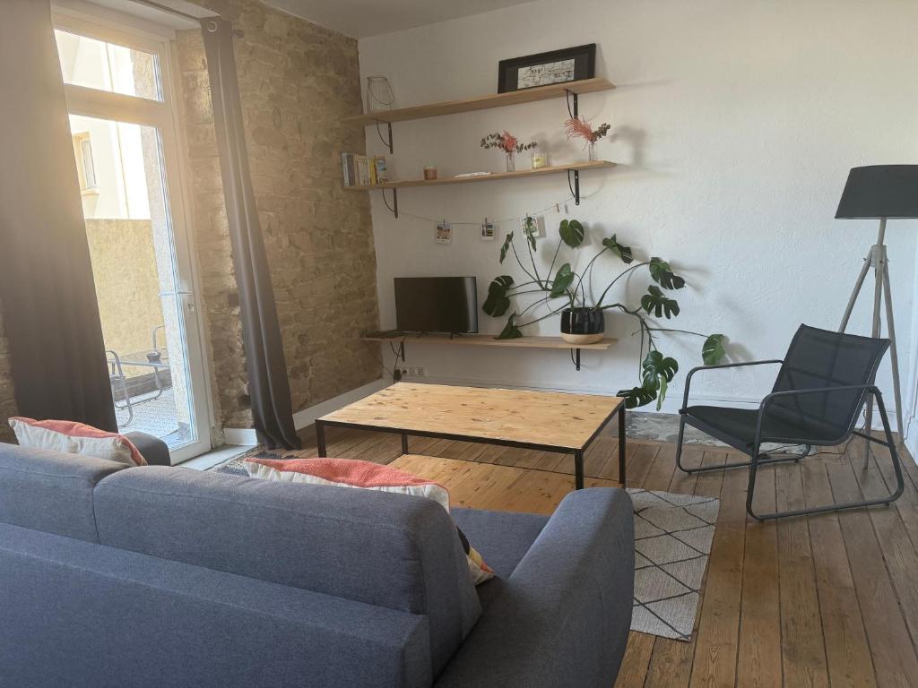 un salon avec un canapé bleu et une table dans l'établissement le liziec, à Vannes