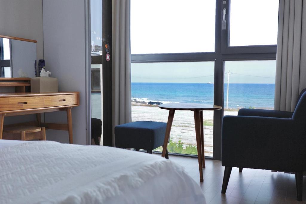 a bedroom with a bed and a view of the ocean at Aewol Bada 23 in Jeju