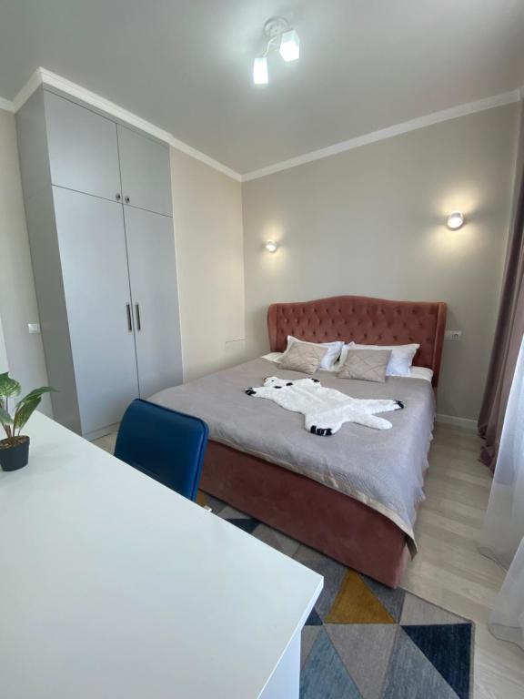 a small bedroom with a bed and a blue chair at Sat City block A in Astana