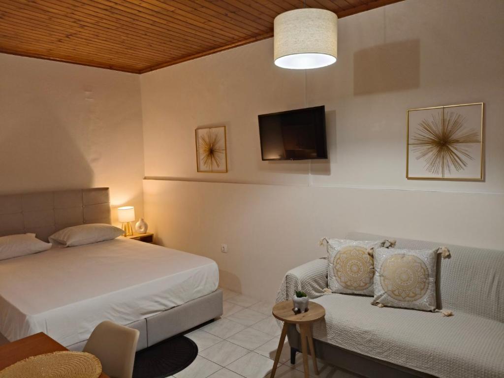 a bedroom with a bed and a chair and a tv at Old Town's Nest in Corfu