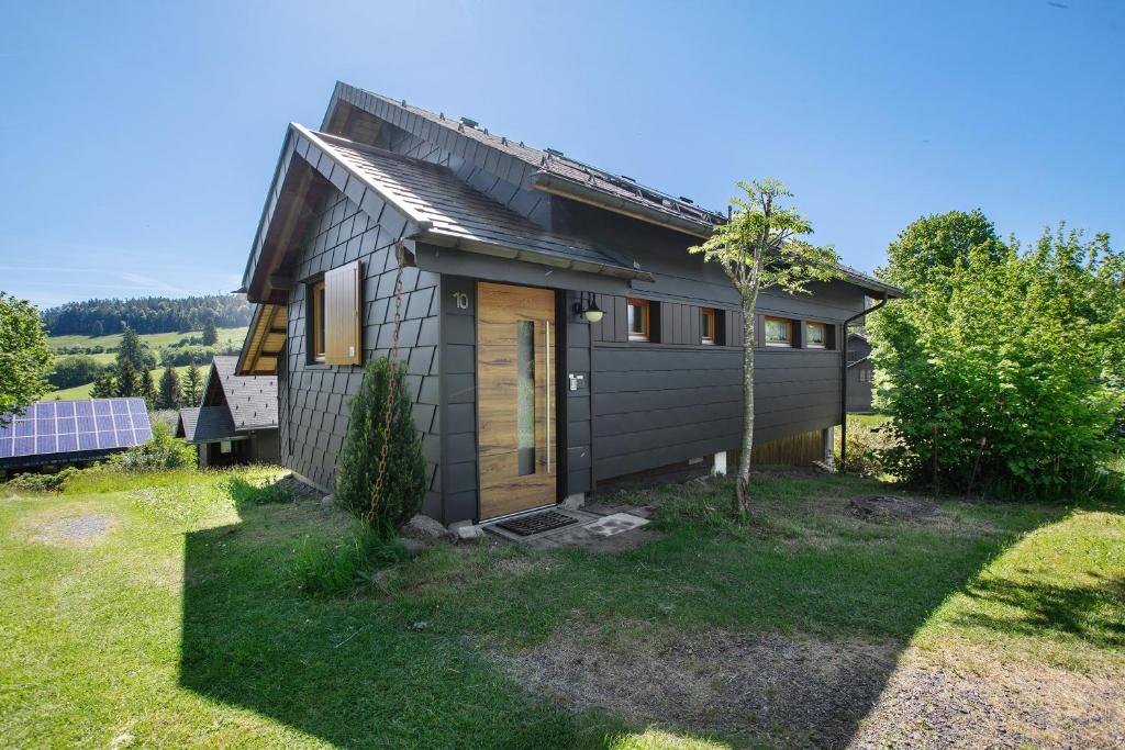 a small house in a yard with a tree at Ferienhaus 10 Rechbergblick in Bernau im Schwarzwald