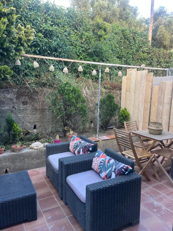 d'une terrasse avec 2 chaises en osier et une table. dans l'établissement Jungle, à Saint-Mandrier-sur-Mer