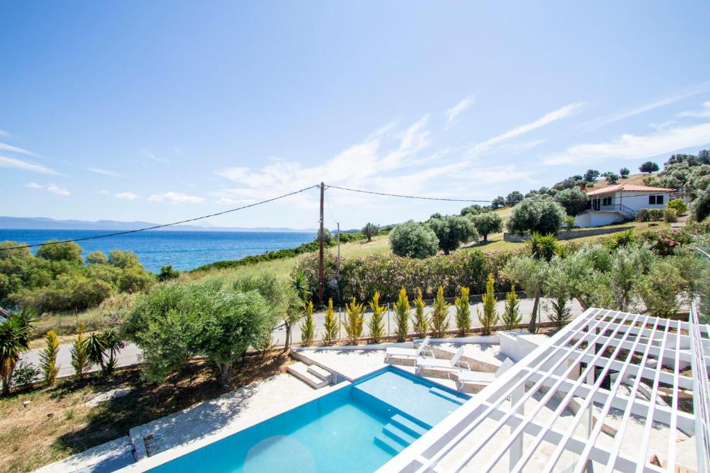 a villa with a swimming pool and a view of the ocean at Daroma Villa, Paliouri by Halkidiki Villas in Paliouri