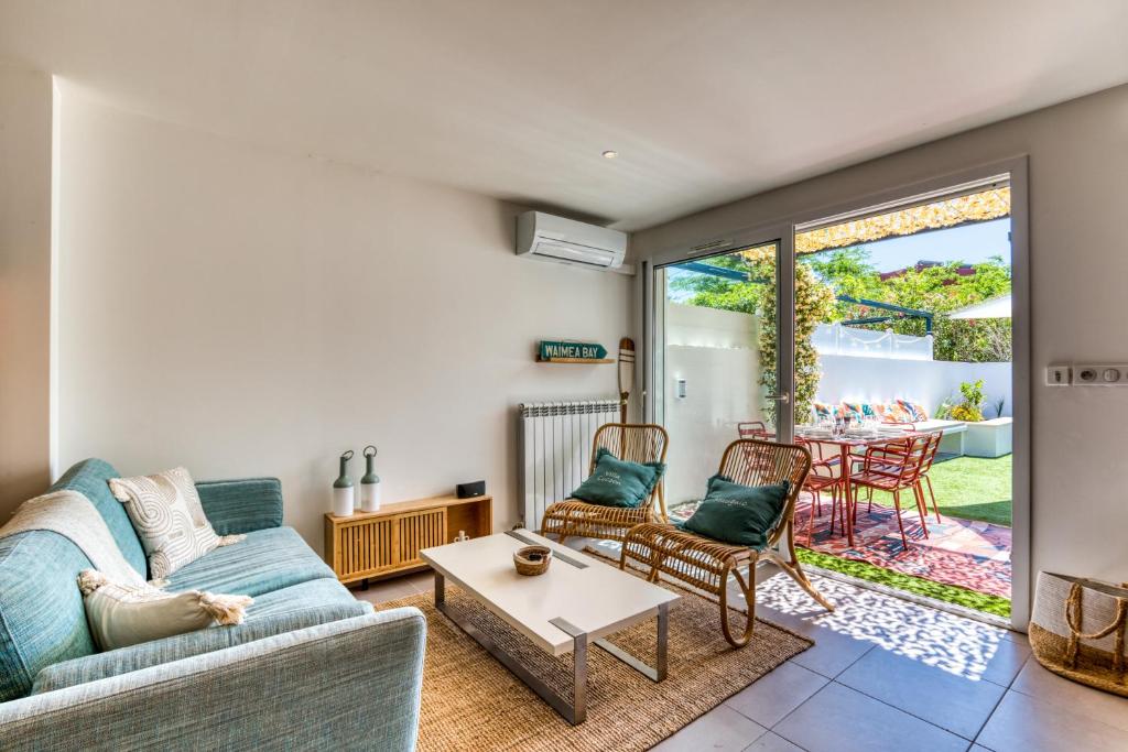 a living room with a couch and chairs and a table at Villa Cocoon Montpellier et plage in Mauguio