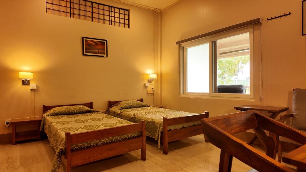 Una cama o camas en una habitación de Golaghat Gymkhana