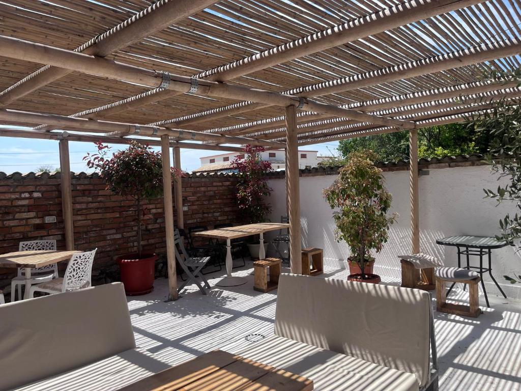 un patio con tavoli e sedie sotto un pergolato in legno di Opera Vama Veche a Vama Veche