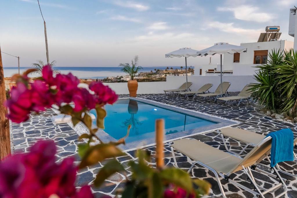 a resort with a swimming pool and chairs at Ciel Blue Villas with Private Pools in Kiotari