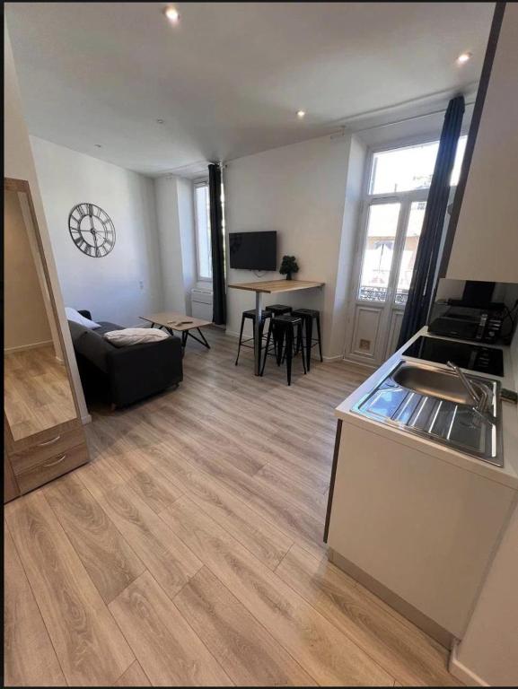 une chambre avec une cuisine et un salon avec une table dans l'établissement Studio Centre Cannes la bocca - 5 min des plages - WIFI Clim, à Cannes
