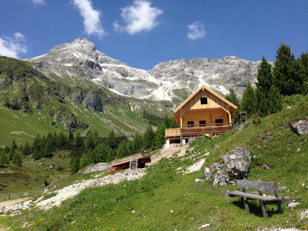 drewniany domek na wzgórzu z górami w tle w obiekcie Haus Santorum w mieście Sankt Michael im Lungau