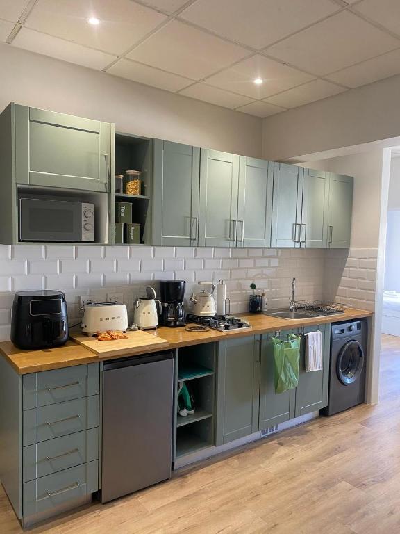a kitchen with green cabinets and a stove top oven at Pistachio - Paarl - Self Catering Apartment in Paarl