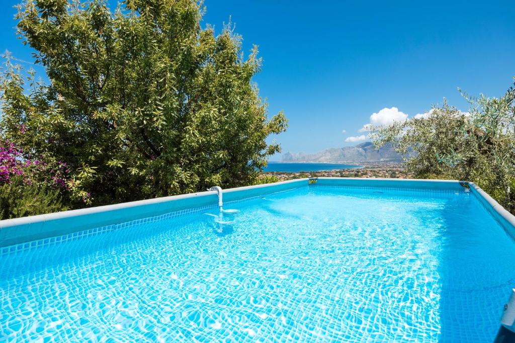 una piscina azul con vistas al océano en Villa Anna Messina, en Carini