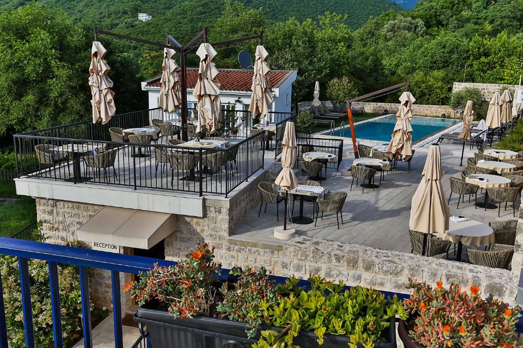 a restaurant with tables and umbrellas next to a pool at Boutique hotel Ruzmarin SPA & Garden by Aycon in Budva