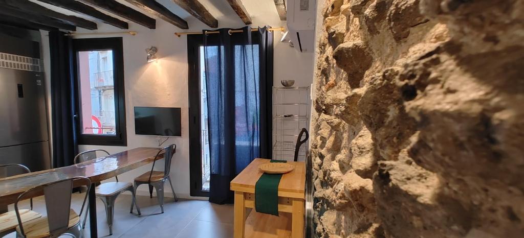 a dining room with a table and a stone wall at TAO.casa METAL in Olot