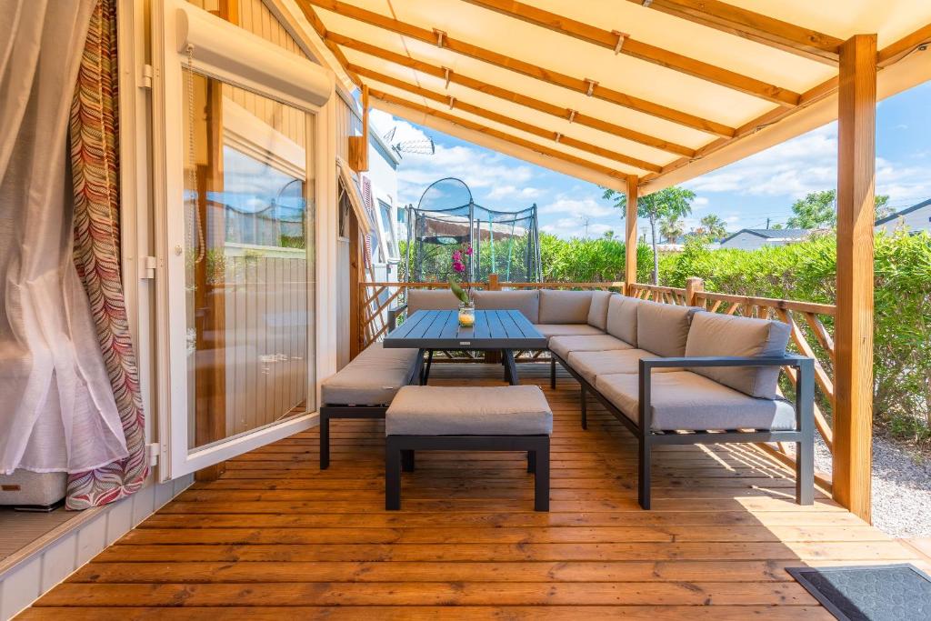- une terrasse couverte avec un canapé, une table et des chaises dans l'établissement Le Mediterranéen, à Fréjus