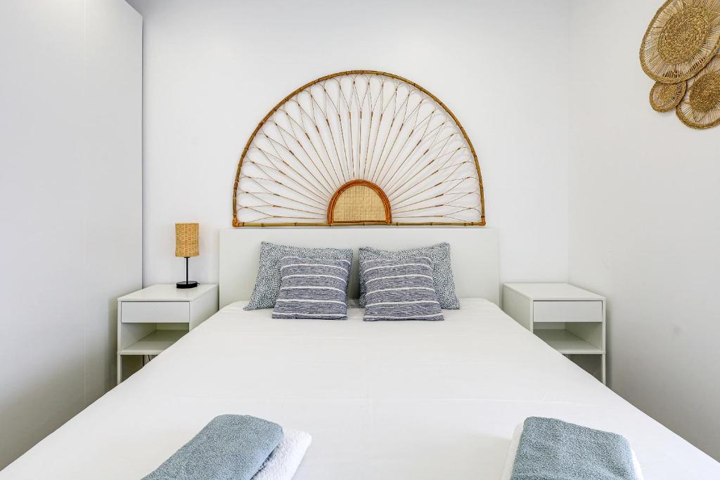 une chambre avec un lit blanc avec des oreillers bleus dans l'établissement Casa Baleeira - Modern apartment with Seaview, à Armação de Pêra