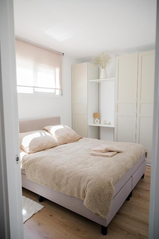 a white bedroom with a bed and white cabinets at Apartamento Casa Gallardo in Blanes