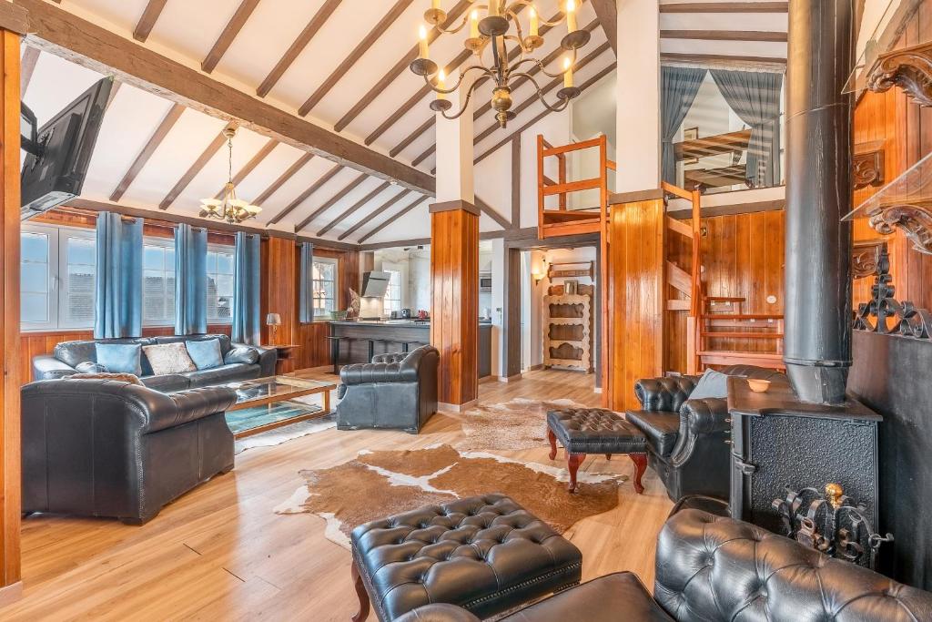 een woonkamer met lederen meubels en een open haard bij Sierra Nevada in Sierra Nevada