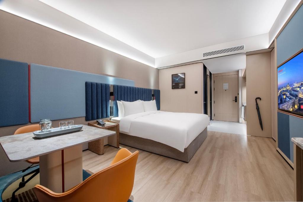 a hotel room with a bed and a tv at IntercityHotel Shanghai Hongqiao Airport - Free Minibar for First Night in Shanghai