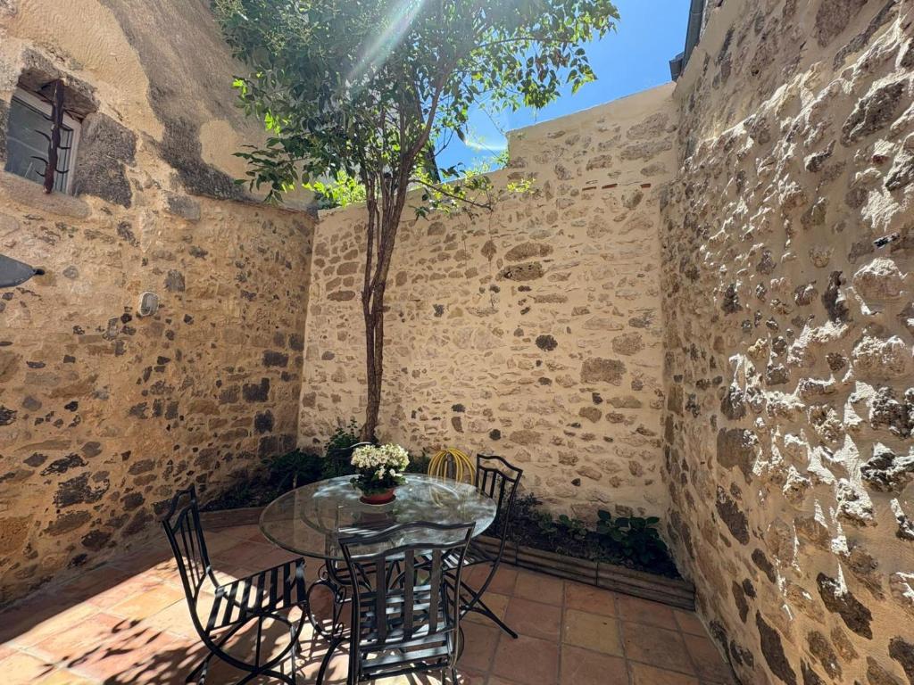 a patio with a table and chairs and a tree at Charmante maison rénovée in Nérac